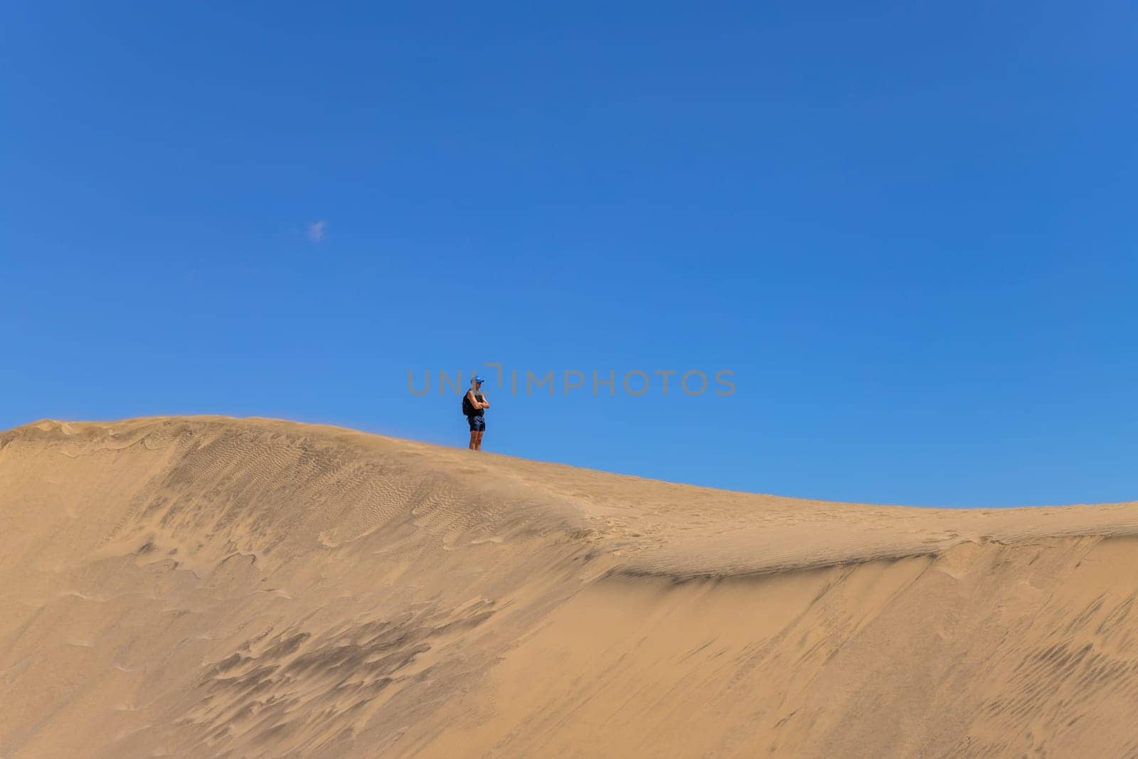 Maspalomas, Gran Canaria: March 20, 2025: Man at the Natural Reserve of Dunes of Maspalomas, golden sand dunes. Canary Islands, Spain