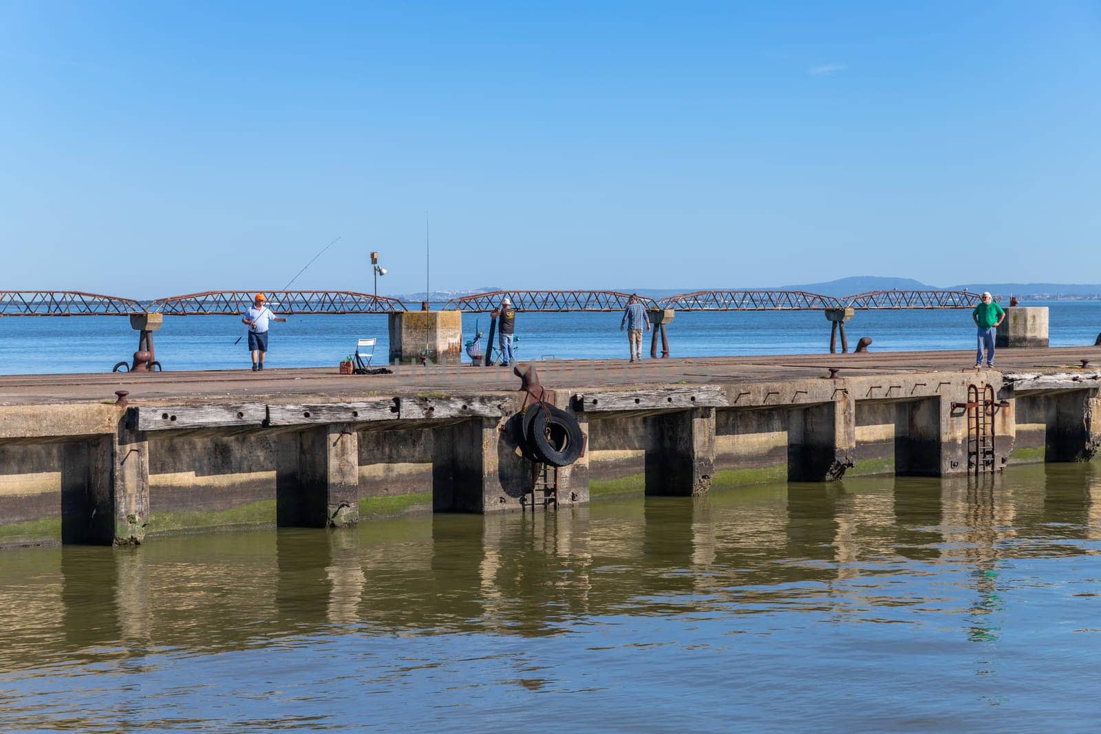 Lisbon, Portugal: April 12, 2024: Fishermen at a pier by the Tagus river near Belem, Lisbon, Portugal