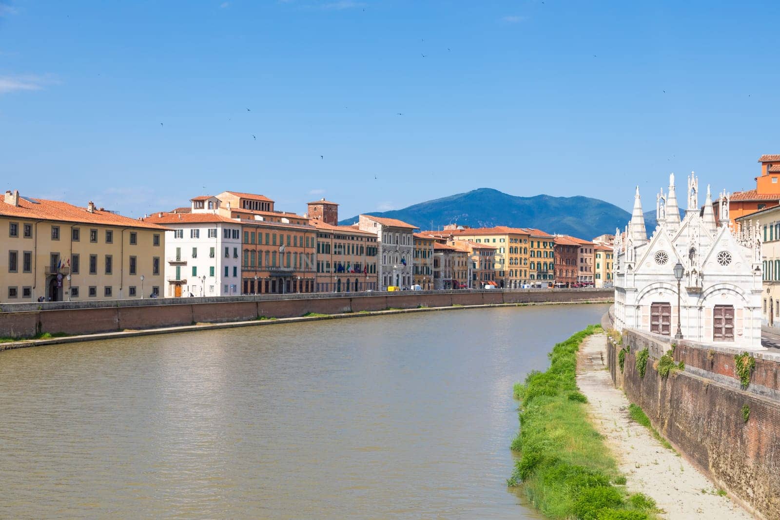 Pisa, Italy - 29 June 2023: colourful buildings on Arno river. Urban skyline, travel destination.