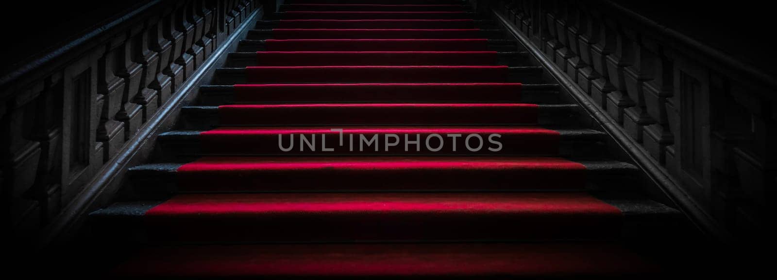 Vintage dark staircase with red carpet