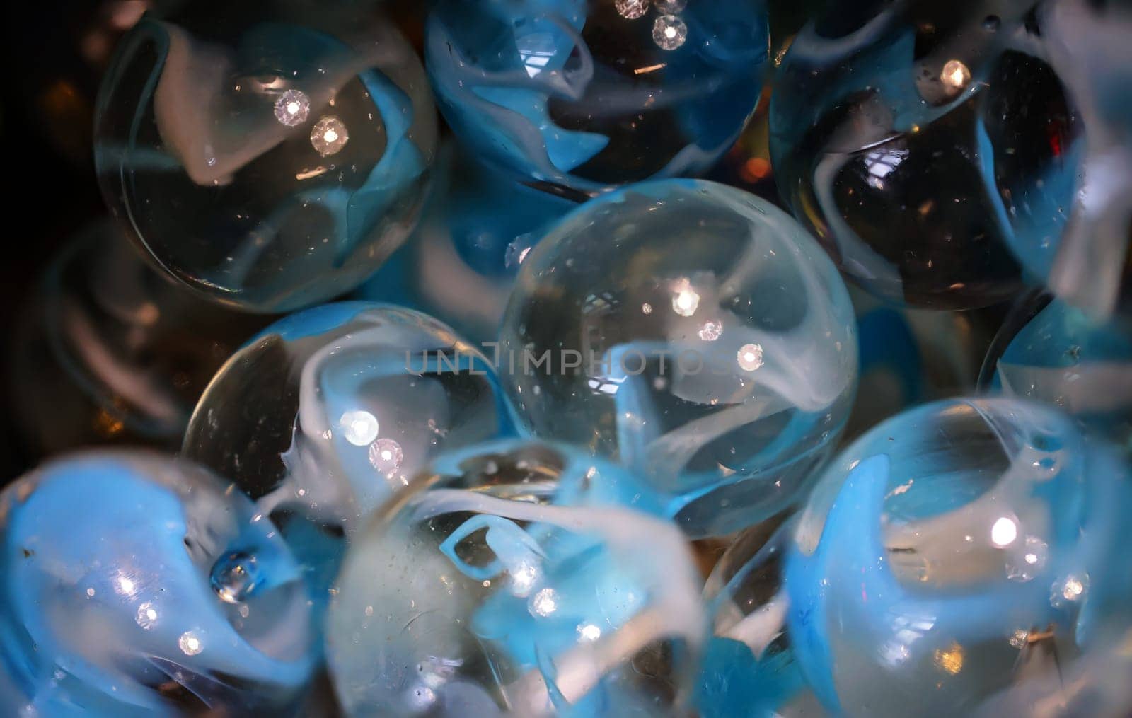 Close-up of many round glass beads in a container.