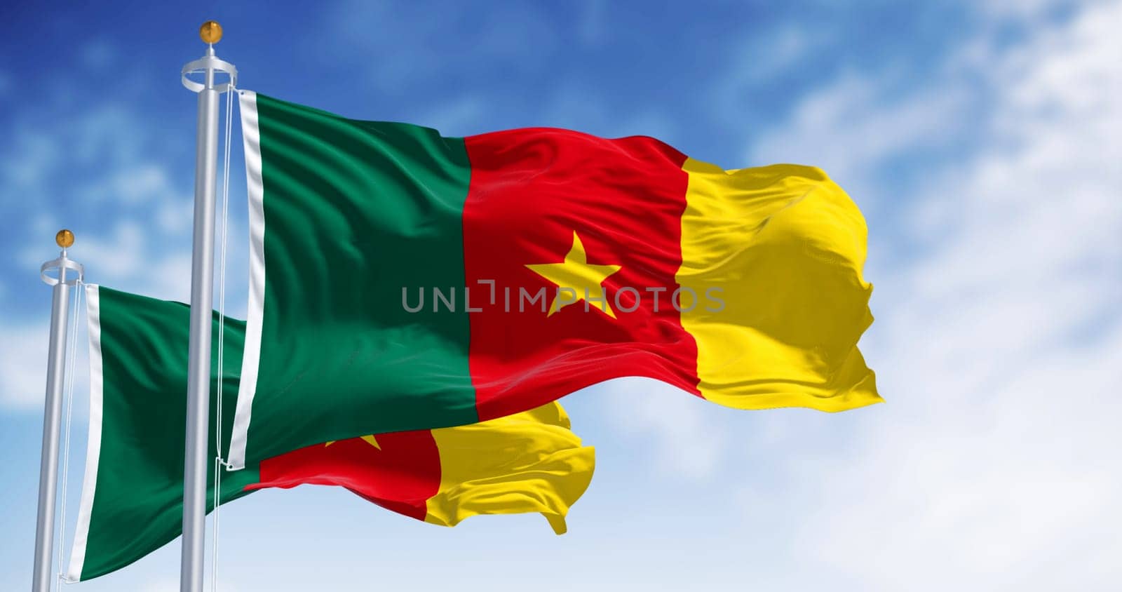 National flags of Cameroon with vibrant green, red, and yellow colors and a central yellow star flaps in the wind against a backdrop of a clear blue sky. 3d illustration render