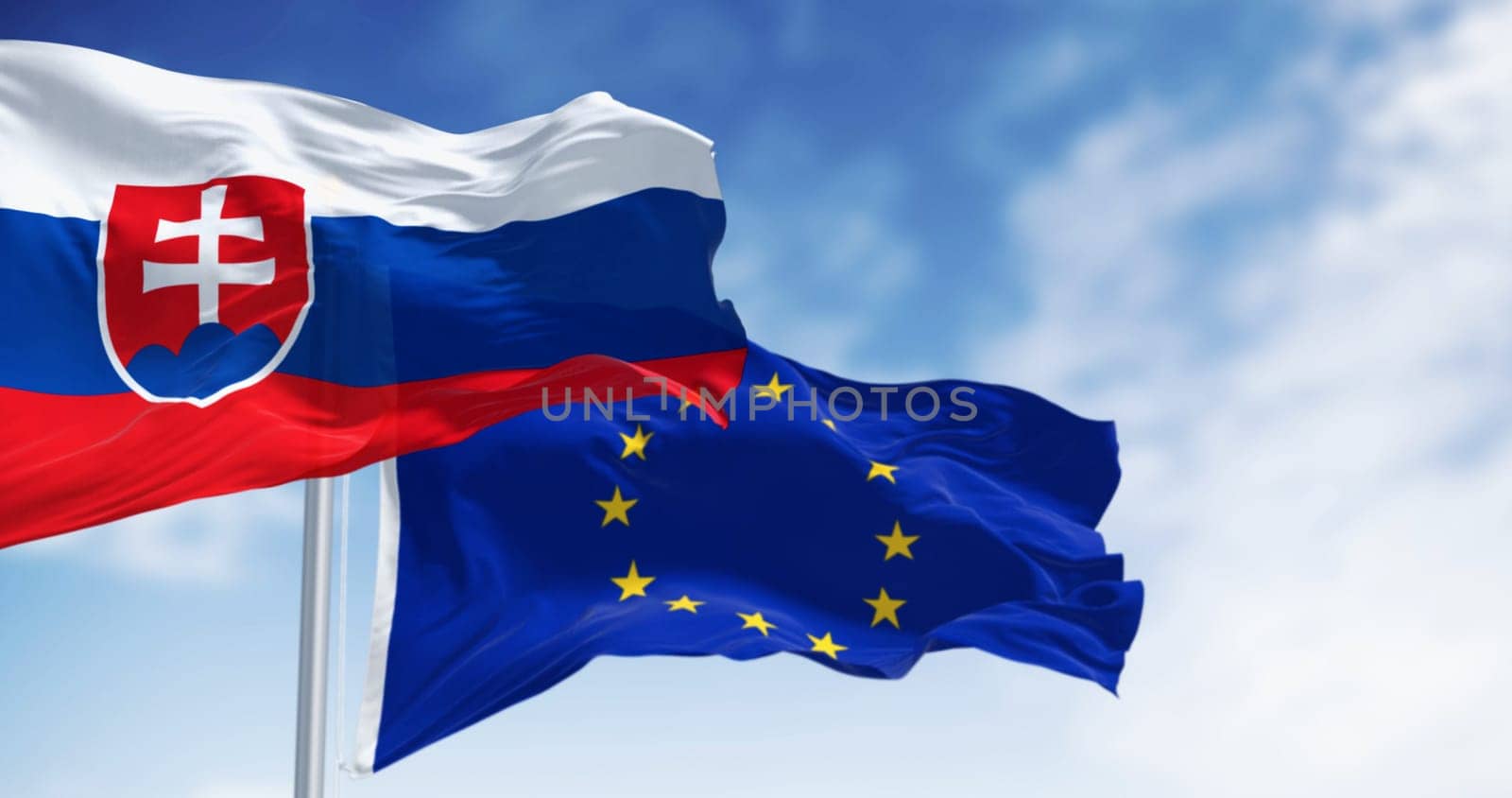 Close-up of Slovakia and the European Union flags waving in the wind on a clear day. 3d illustration render. Fluttering fabric. Selective focus