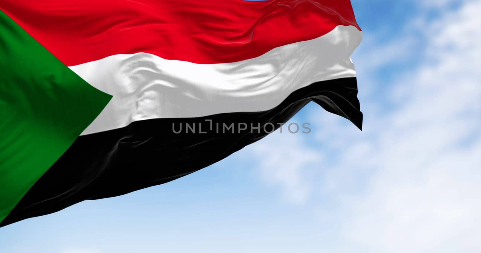 Sudan national flag waving in the wind. Red, white, black horizontal stripes with a green triangle at the hoist. 3d illustration render. Rippling fabric