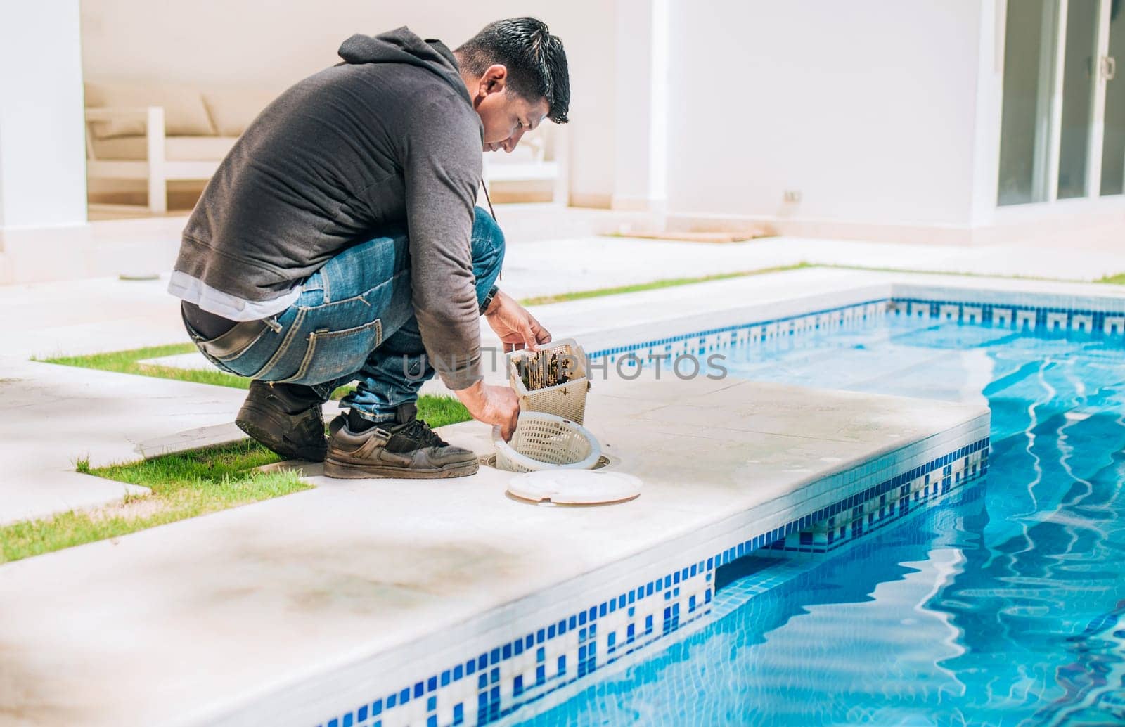 Man cleaning swimming pool filter basket. Person cleaning garbage filter basket for swimming pool