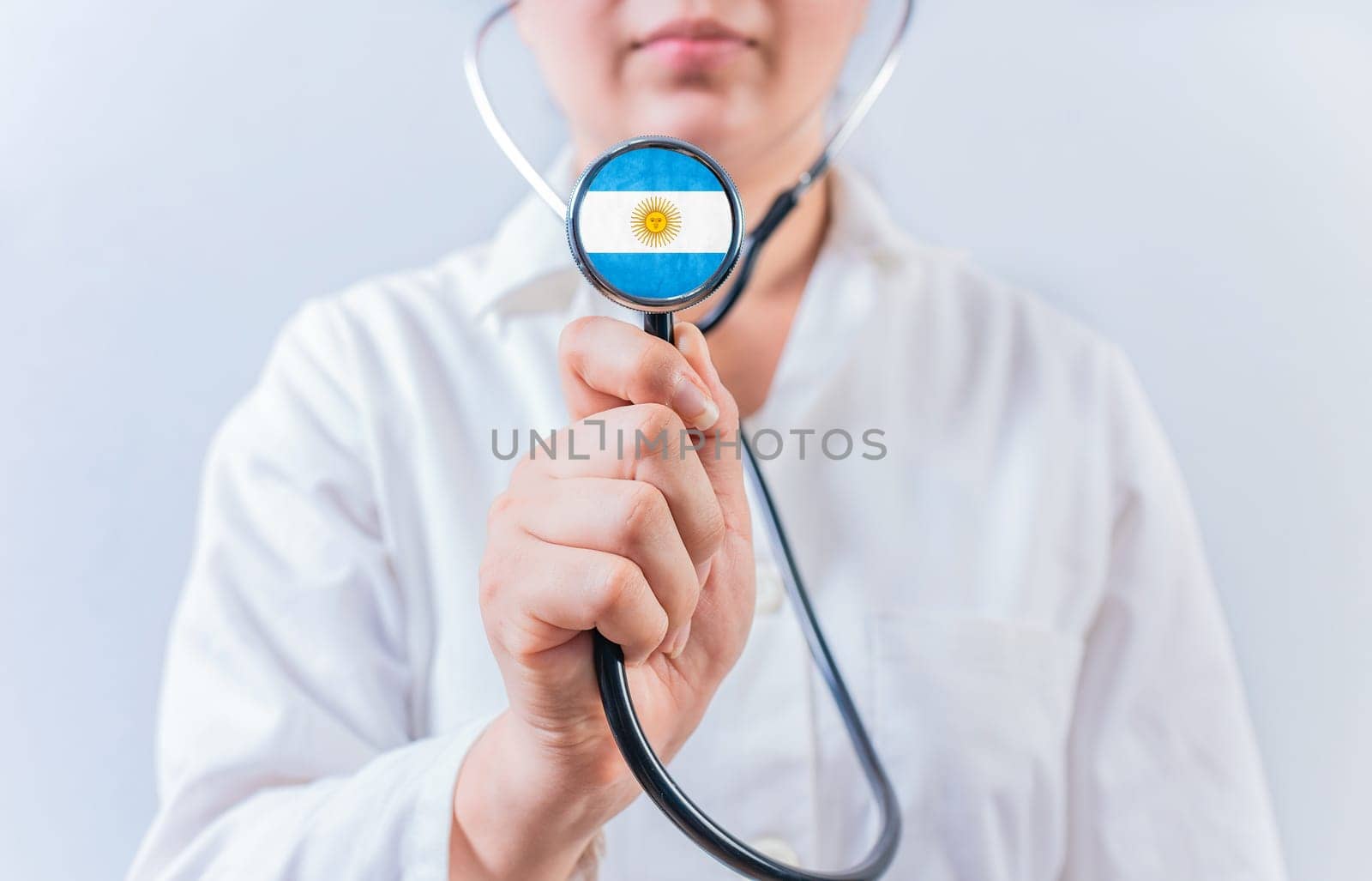 Female doctor holding stethoscope with Argentina flag. Argentine Health and Care concept