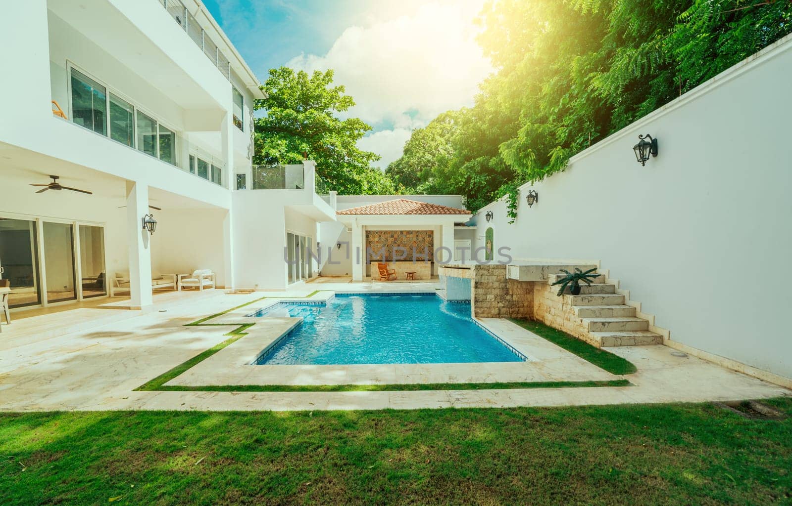 Beautiful crystal clear swimming pool in a backyard. Swimming pool surrounded by nature trees