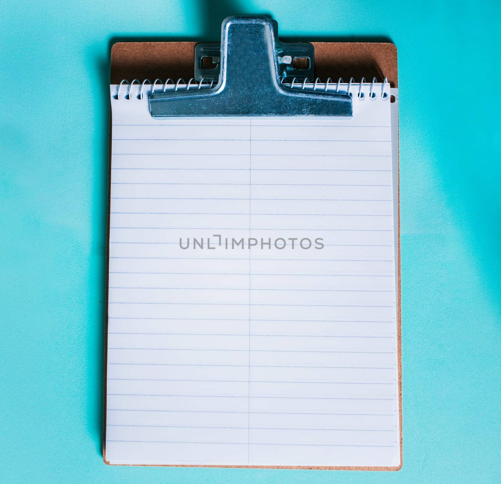 Top view of notepad on isolated background. Note book on clipboard on color background