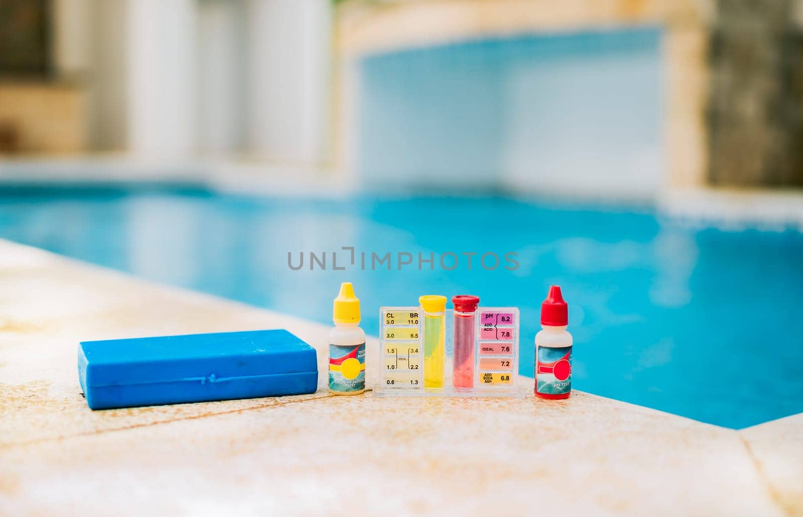 Water test kit on the edge of the swimming pool. Chlorine test kit for swimming pools. Chlorine and ph tester for swimming pools