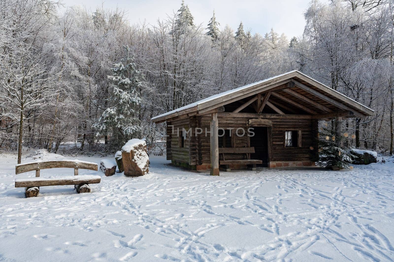 A log cabin in winter with lots of snow and trees