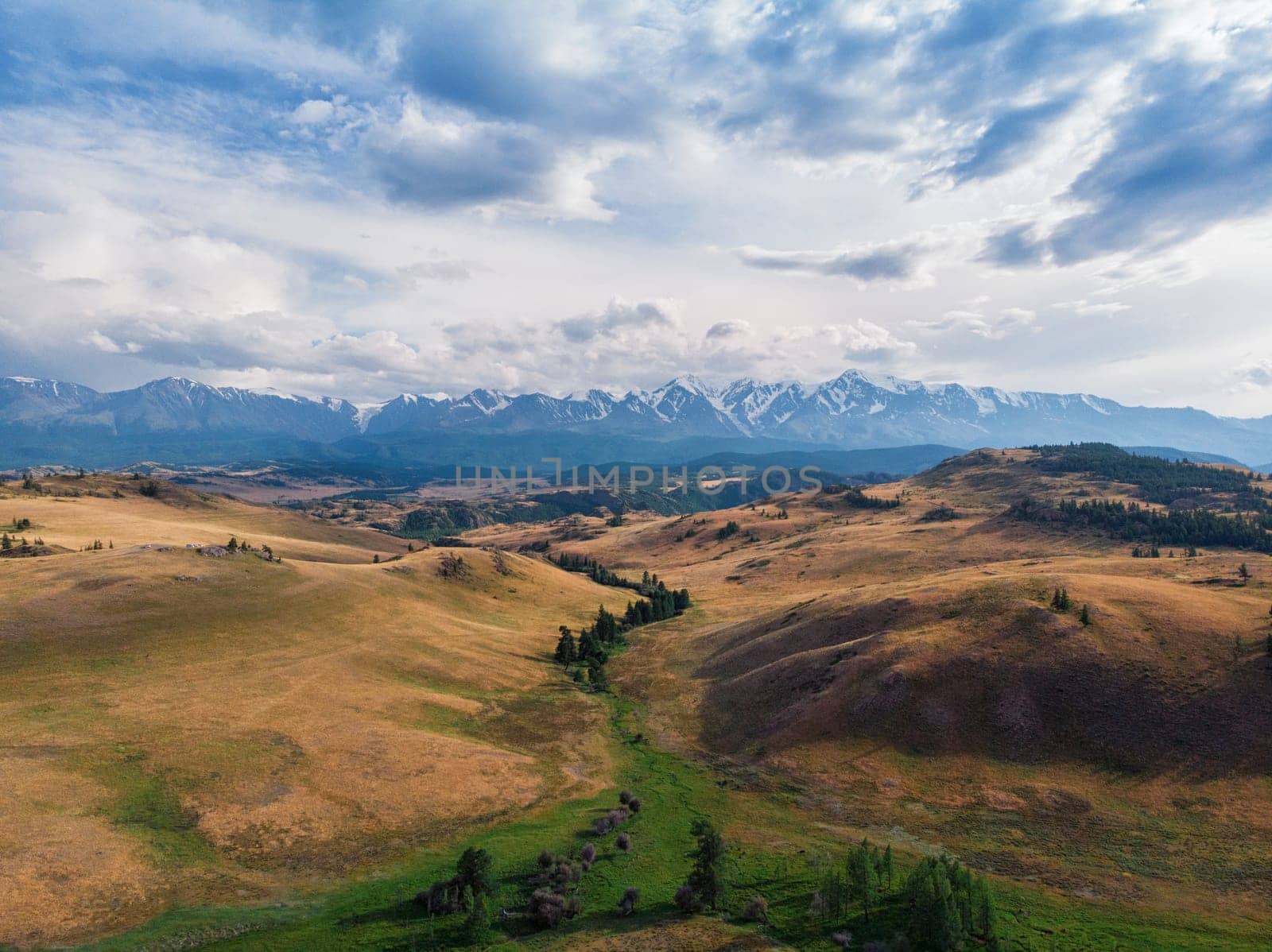 Kurai steppe and Chuya river on North-Chui ridge mountains background. Altai mountains, Russia. Aerial drone panoramic picture.