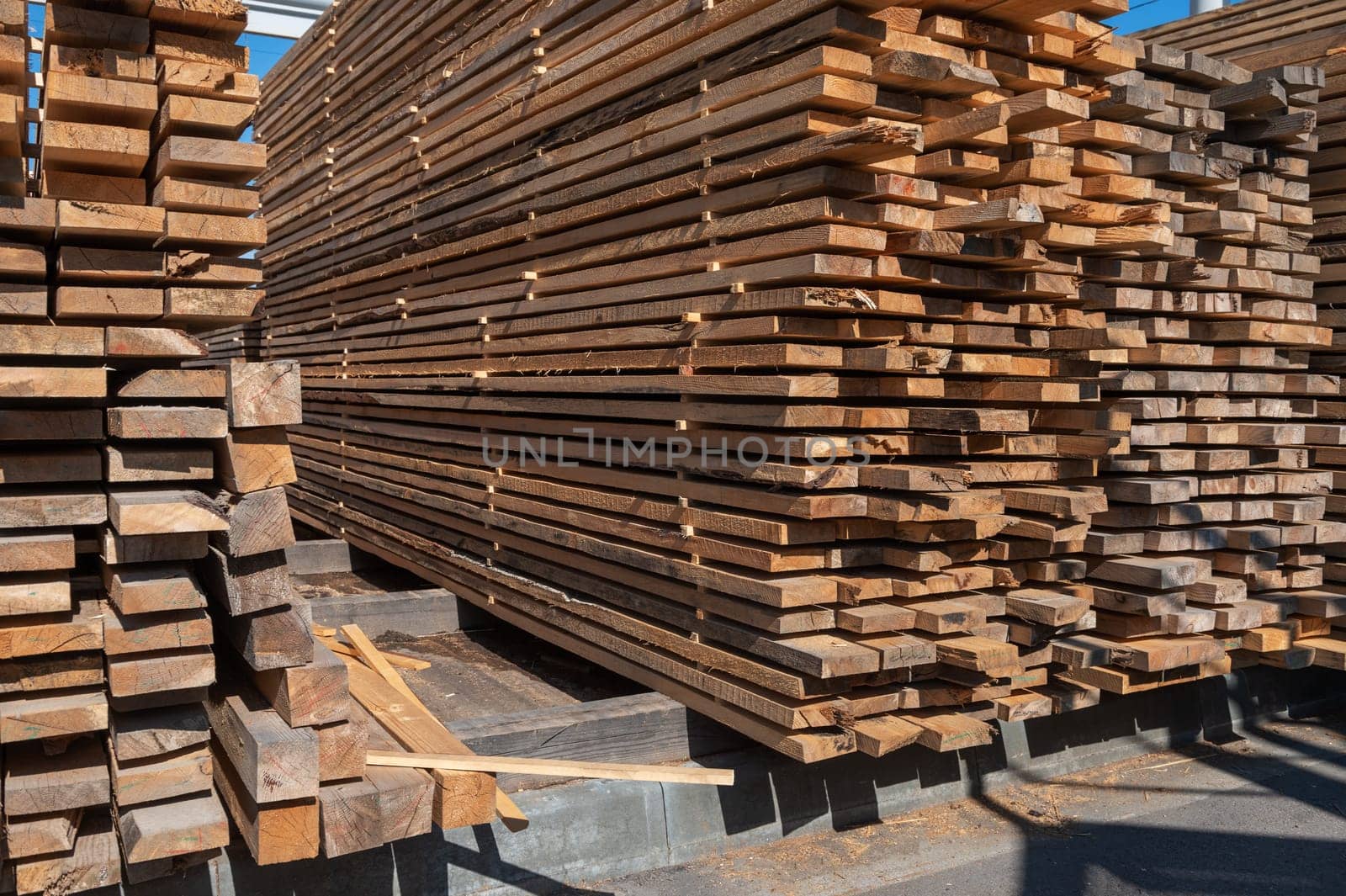 Stacked wooden planks close-up at lumber warehouse. Wood industry concept