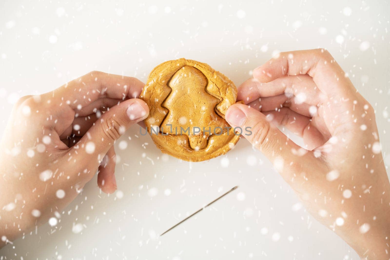 Brown sugar caramel candy cookies with a metal needle in the shape of a fir tree on a white background.