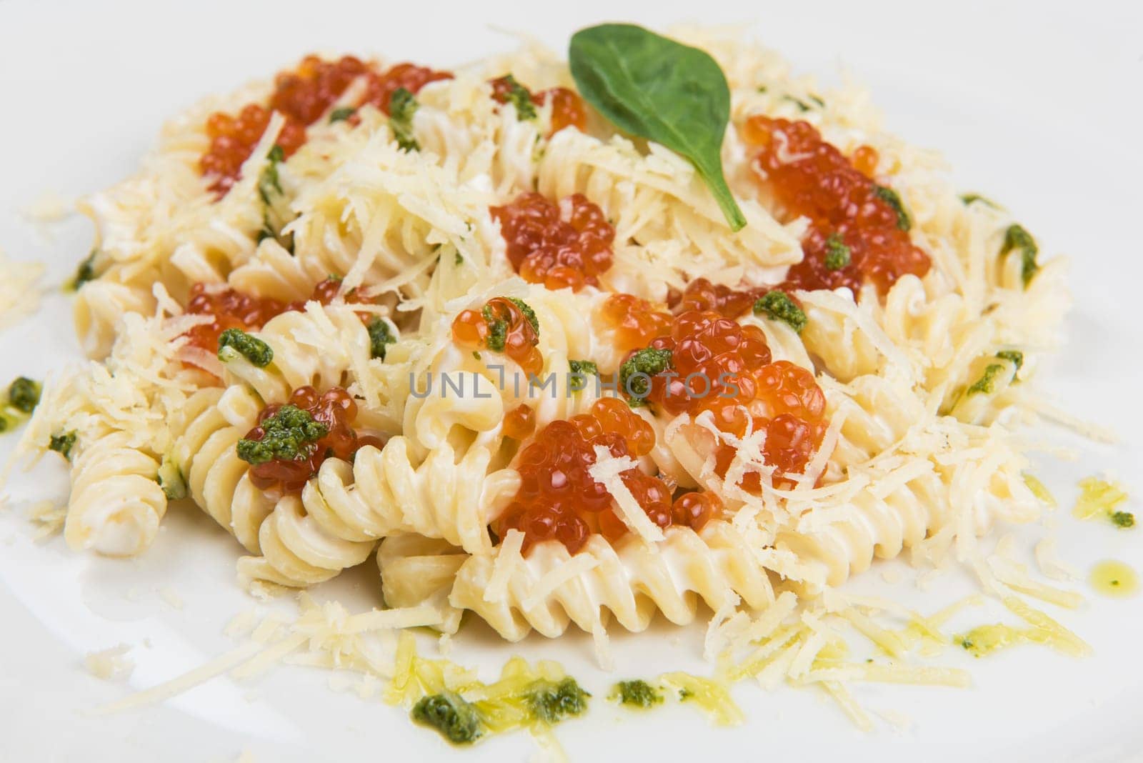 Pasta with parmesan cheese basil and red caviar. The concept of Italian cuisine.