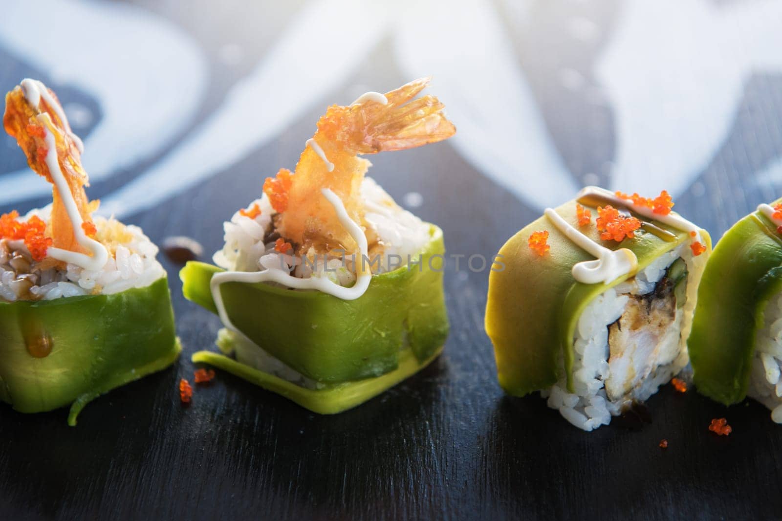 Various kinds of sushi served on wood black table.