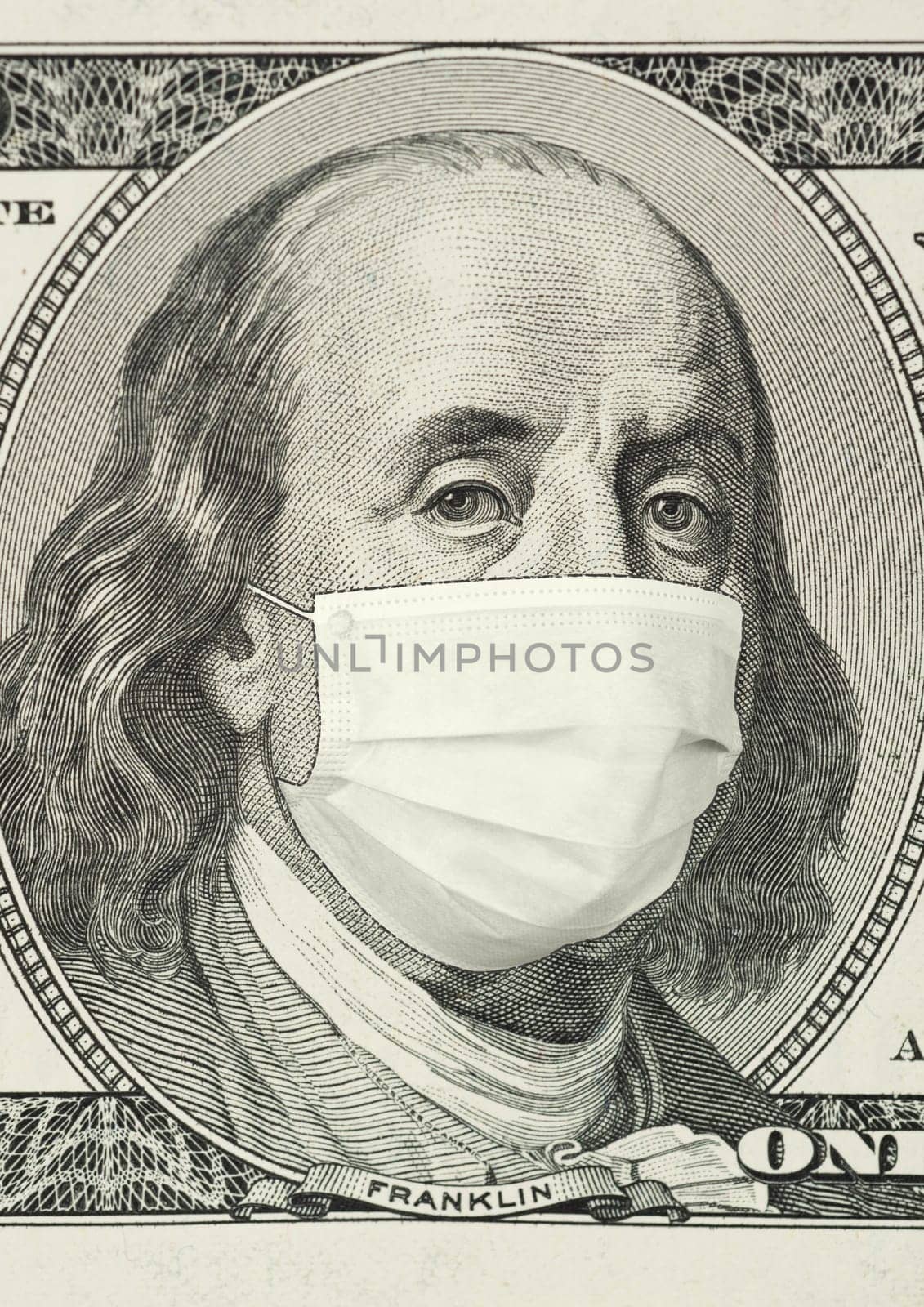 Portrait of Franklin on 100 dollar banknote with medical mask. The concept of coronavrius epidemic and the financial crisis caused by this collapse