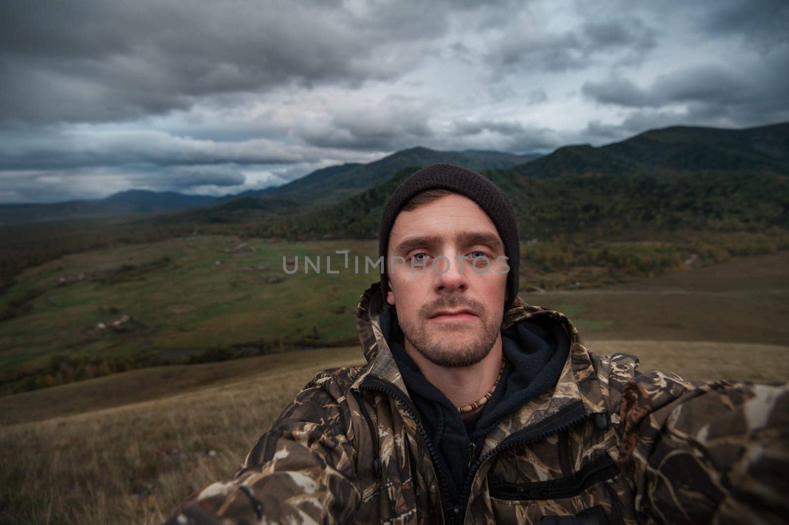 Caucasian man in the mountain making selfie on background nature landscape
