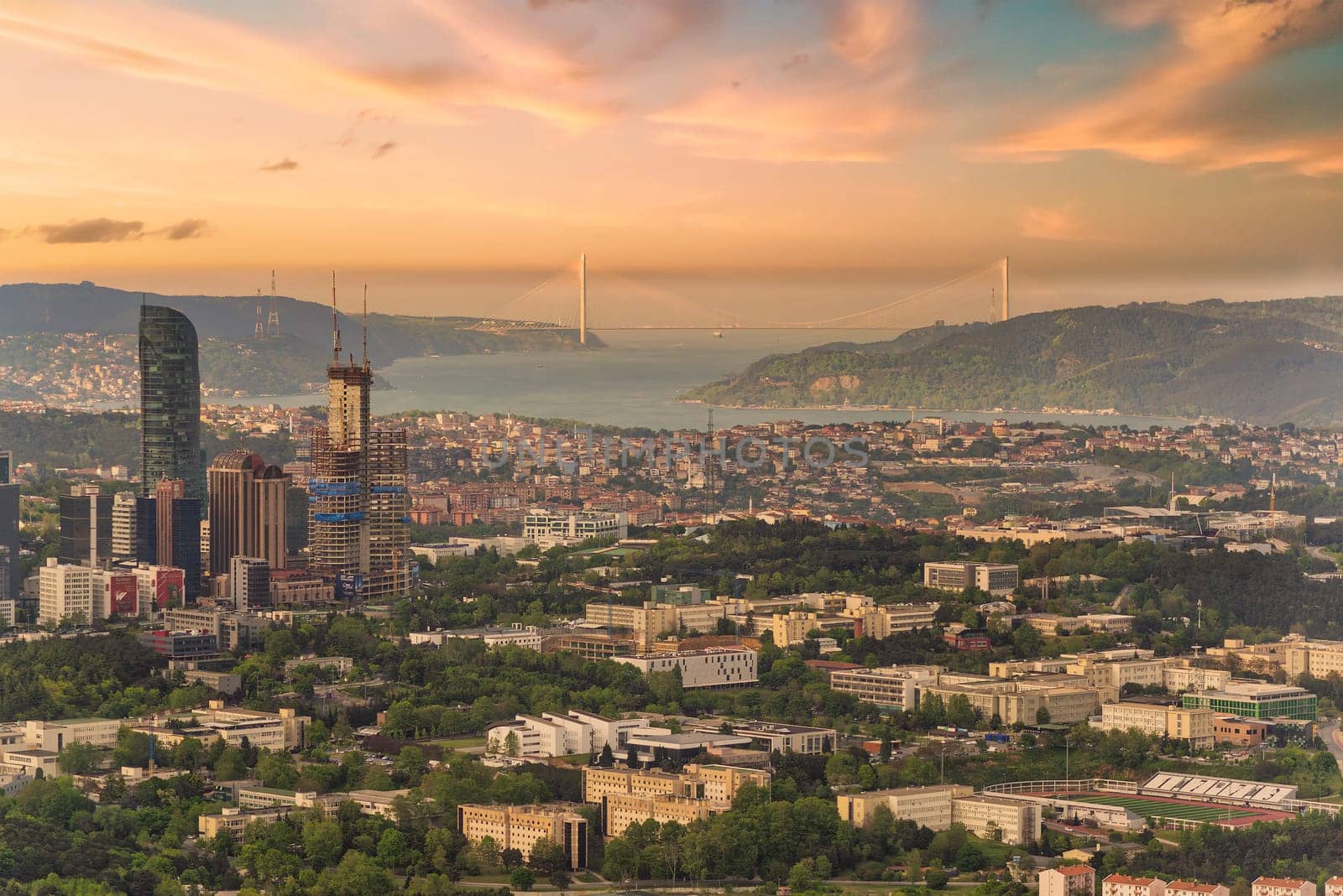 A panoramic sunset casts a warm glow over Istanbuls cityscape and the Bosphorus Strait, showcasing the urban and natural beauty. Photo taken from Istanbul Sapphire tower, Turkey