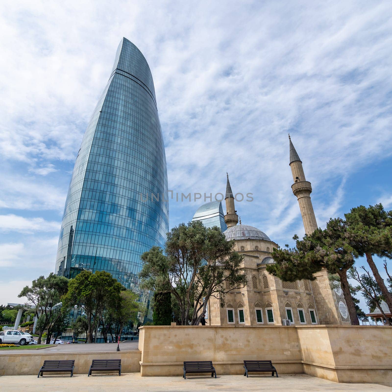 The Sehitler Mosque, or Mosque of the Martyrs stands prominently in front of the Flame Towers in Baku, Azerbaijan