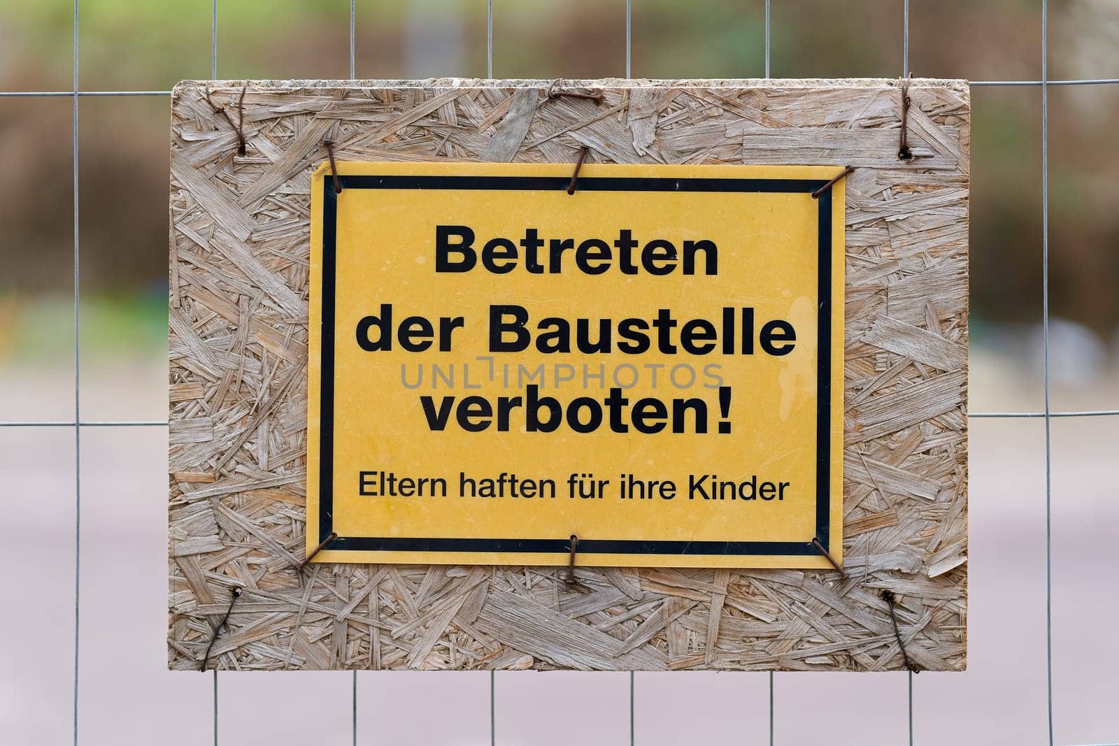 Sign on a fence with the german inscription Betreten der Baustelle verboten. Translation: No trespassing on the construction site
