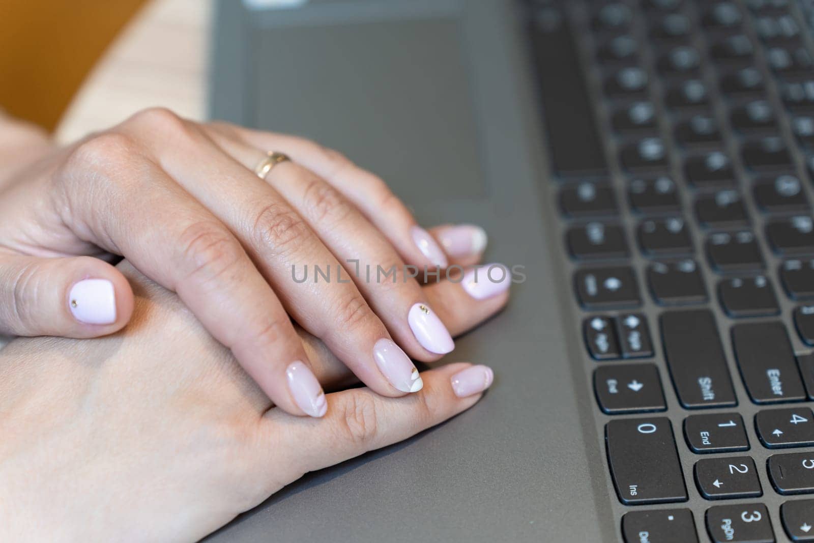 woman hands typing on laptop keyboard in a cafe.