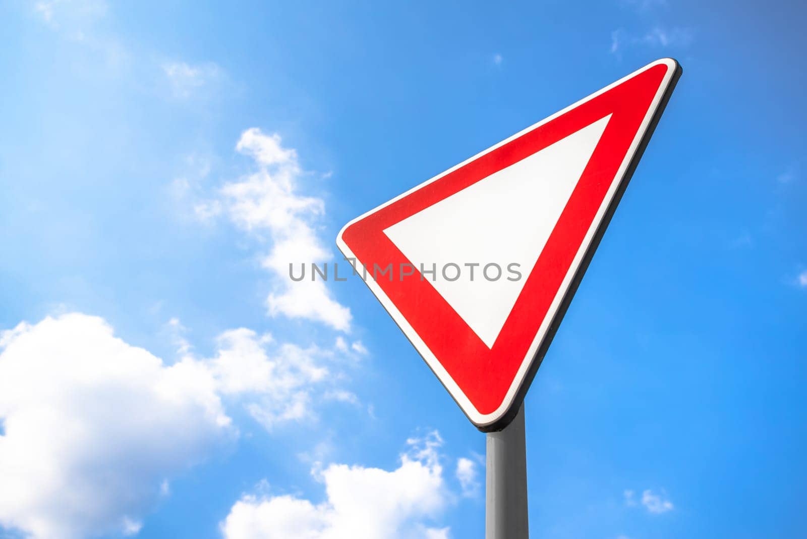 Yield Right-of-Way. This sign indicates driver must yield to traffic on the upcoming priority road. If necessary, come to a complete stop to allow traffic on the priority road to clear before proceeding.