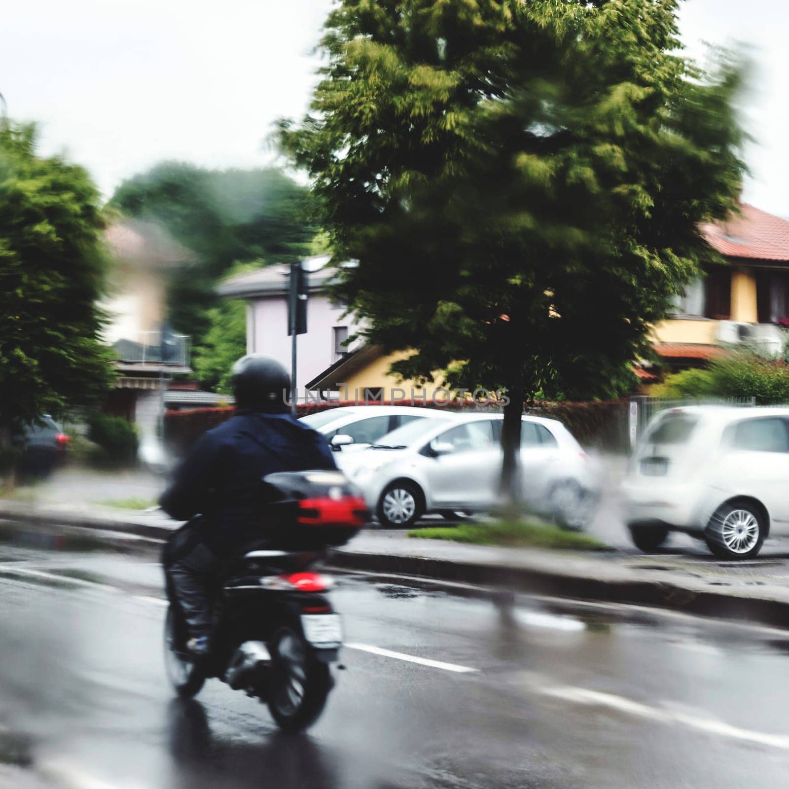 Man in the rain with his motorcycle. Man riding motorcycle in the rain on road.