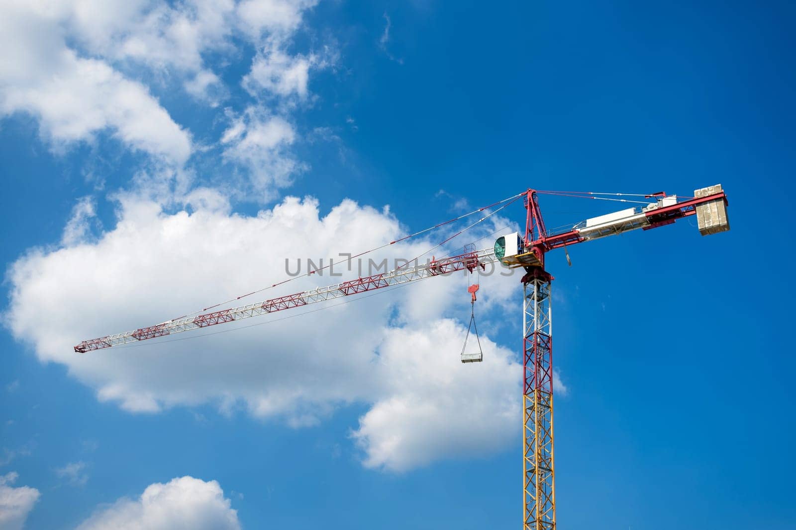 Detail of construction tower crane against blue sky