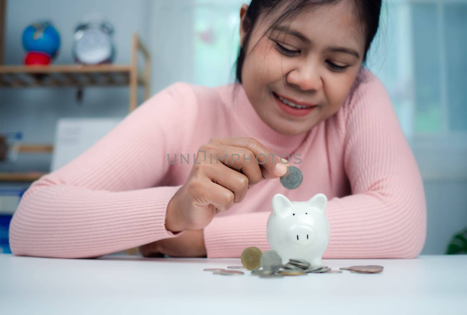 Close-Up Woman put coins in the piggy bank for saving money and financial concept, Business Banking and Financial Concept, Saving money for retirement funds and insurance concept.