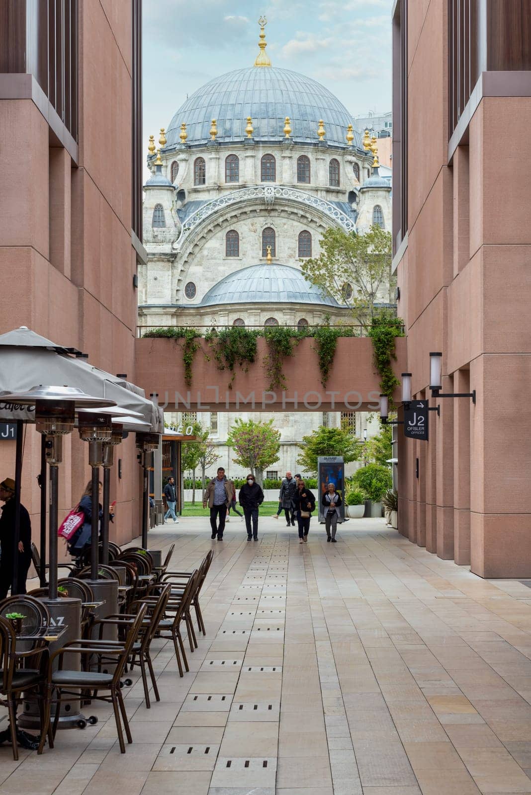 Istanbul, Turkey - May 5, 2023: Nusretiye imperial Ottoman Mosque framed by internal passage at Galataport, a mixed use development located along shore of Bosphorus strait, in Karakoy district