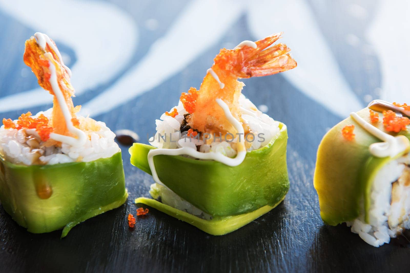 Various kinds of sushi served on wood black table.