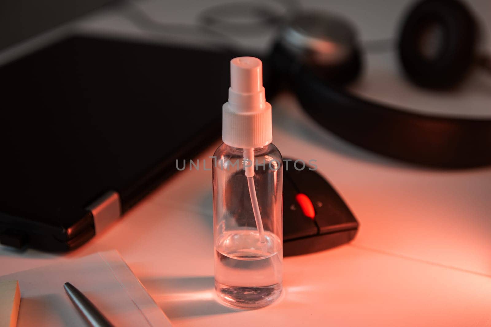 Sanitizer anti virus spray on the working table with laptop. Personal hygiene concept. Concept of quarantine for coronavirus and working from home.