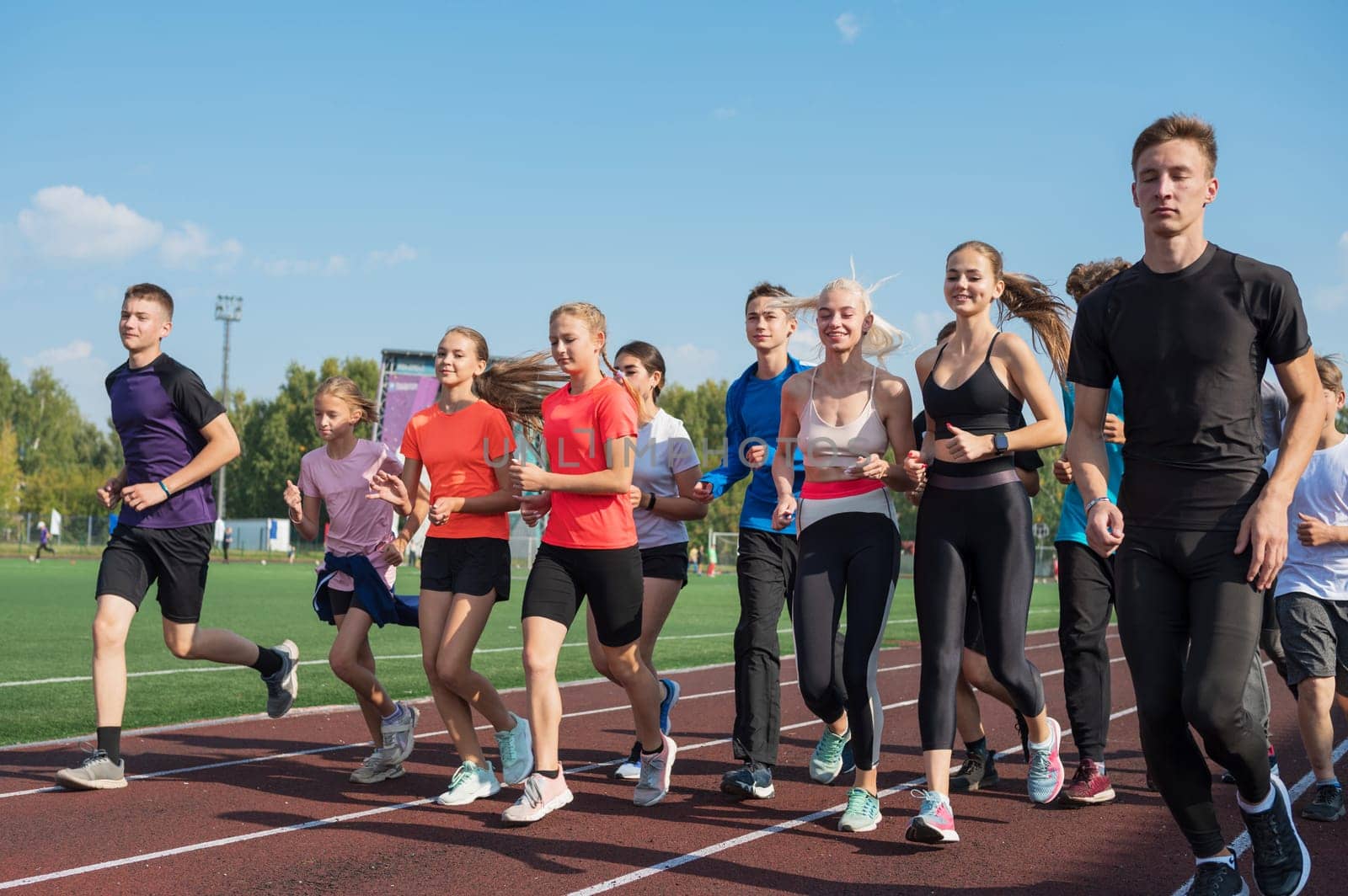Group of young athletes training at the stadium. School gym trainings or athletics