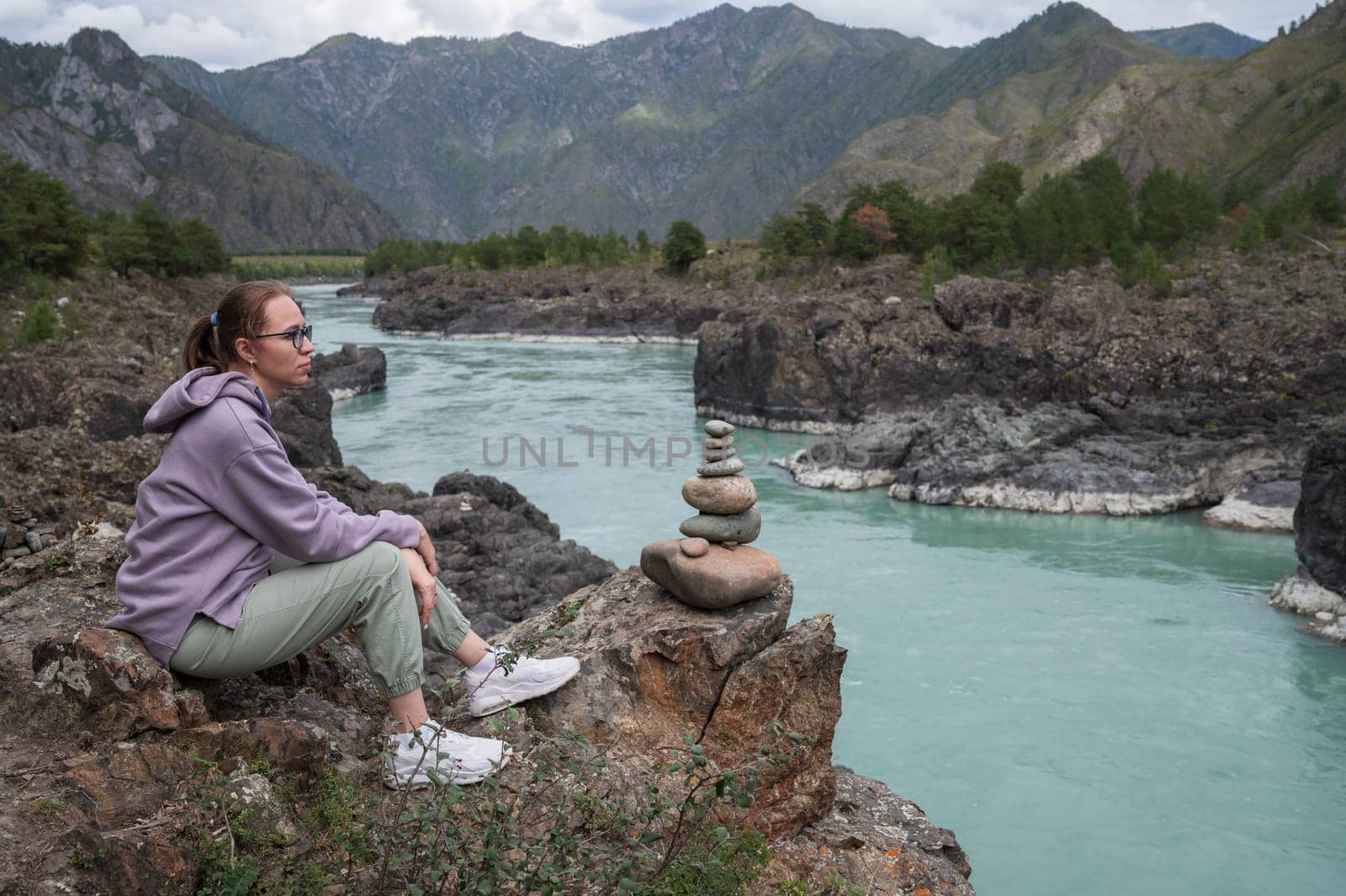 Woman at the river Katun at summer day. Trip on Altai Mountains in Altai Republic
