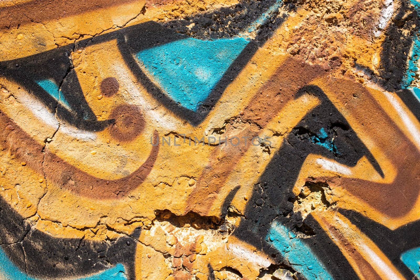 Abstract detail of ochre and turquoise color graffiti painted on the wall in Portugal