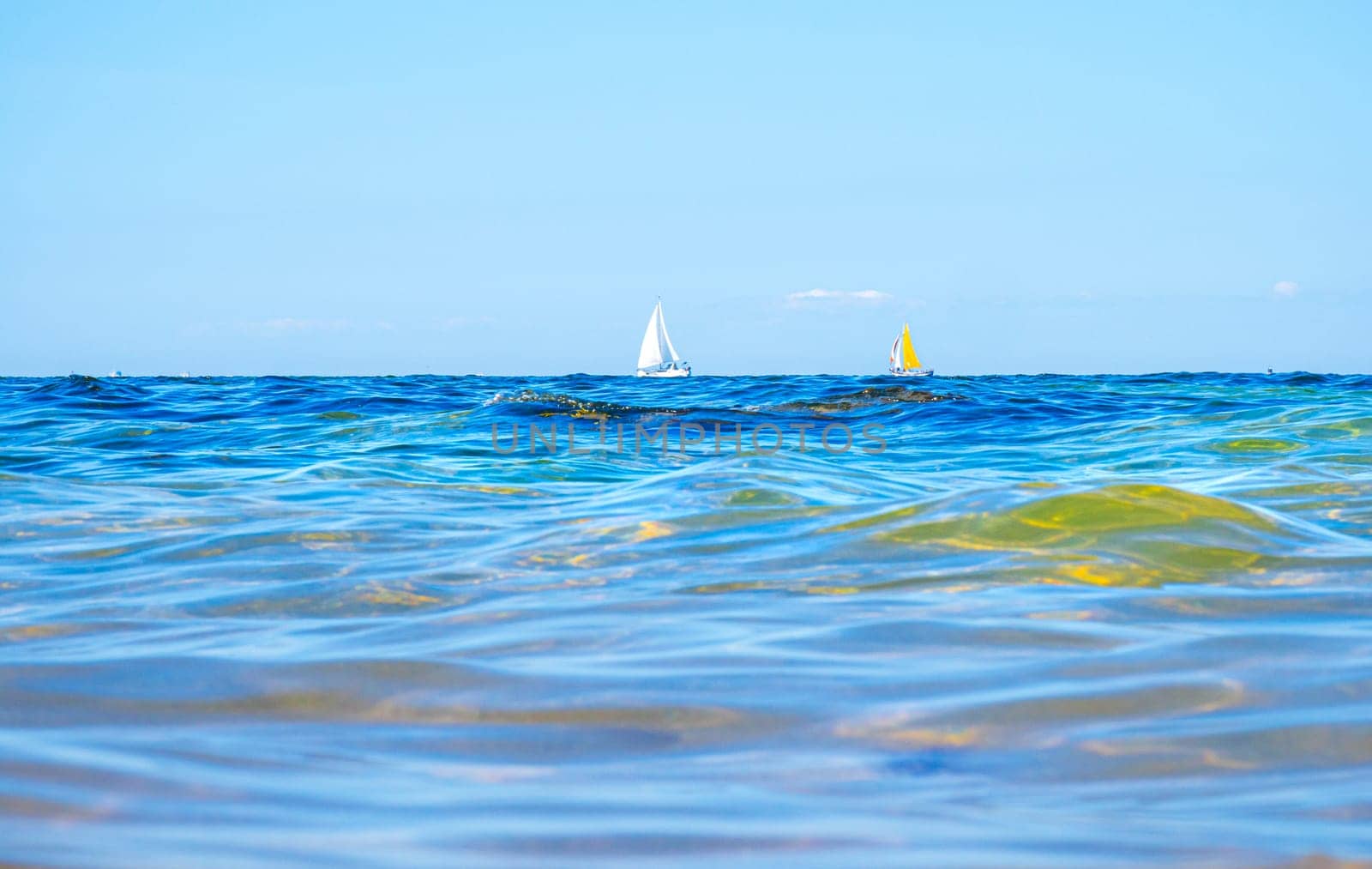 Boats and waves seen by a swimmer at sea level, photography taken in Vendée, France