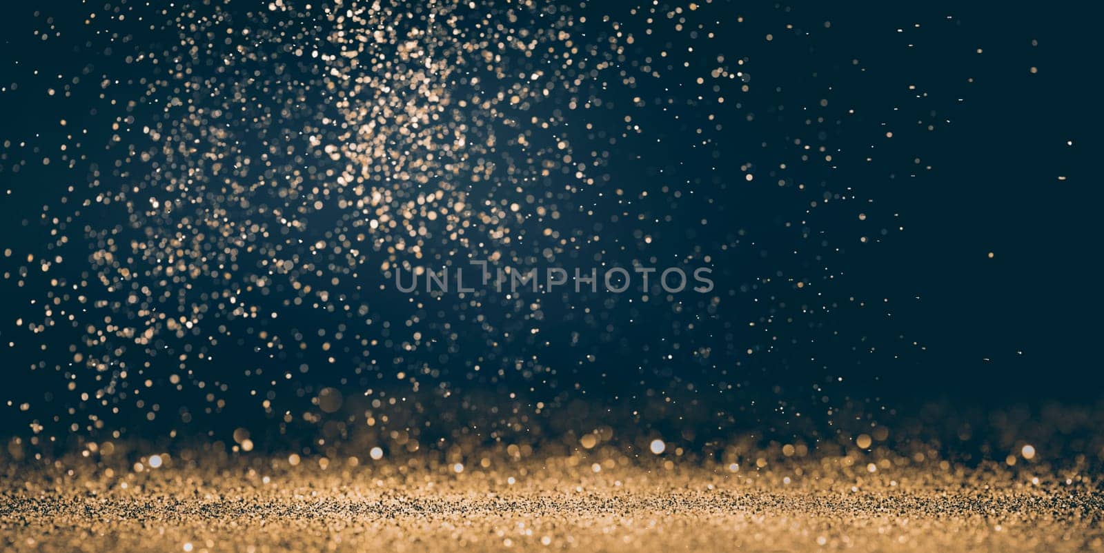 Luxury abstract glitter bokeh background. New year and christmas holiday party design. Golden star dust light sparkling on dark backdrop.