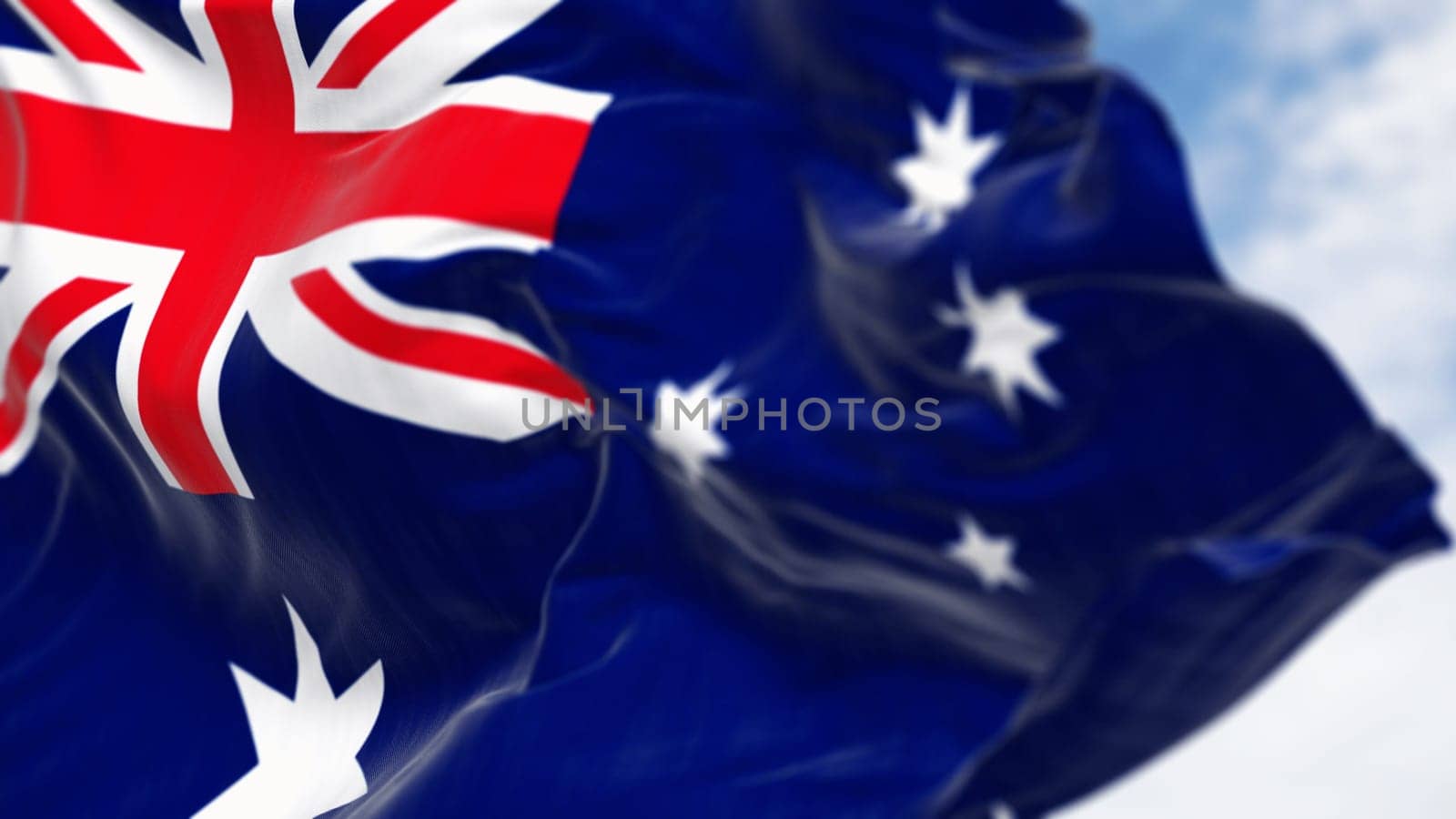 Close-up of Australia national flag waving in the wind on a clear day. Blue flag with Union Jack, white 5-pointed star symbolizing Southern Cross. 3D illustration render. Selective focus