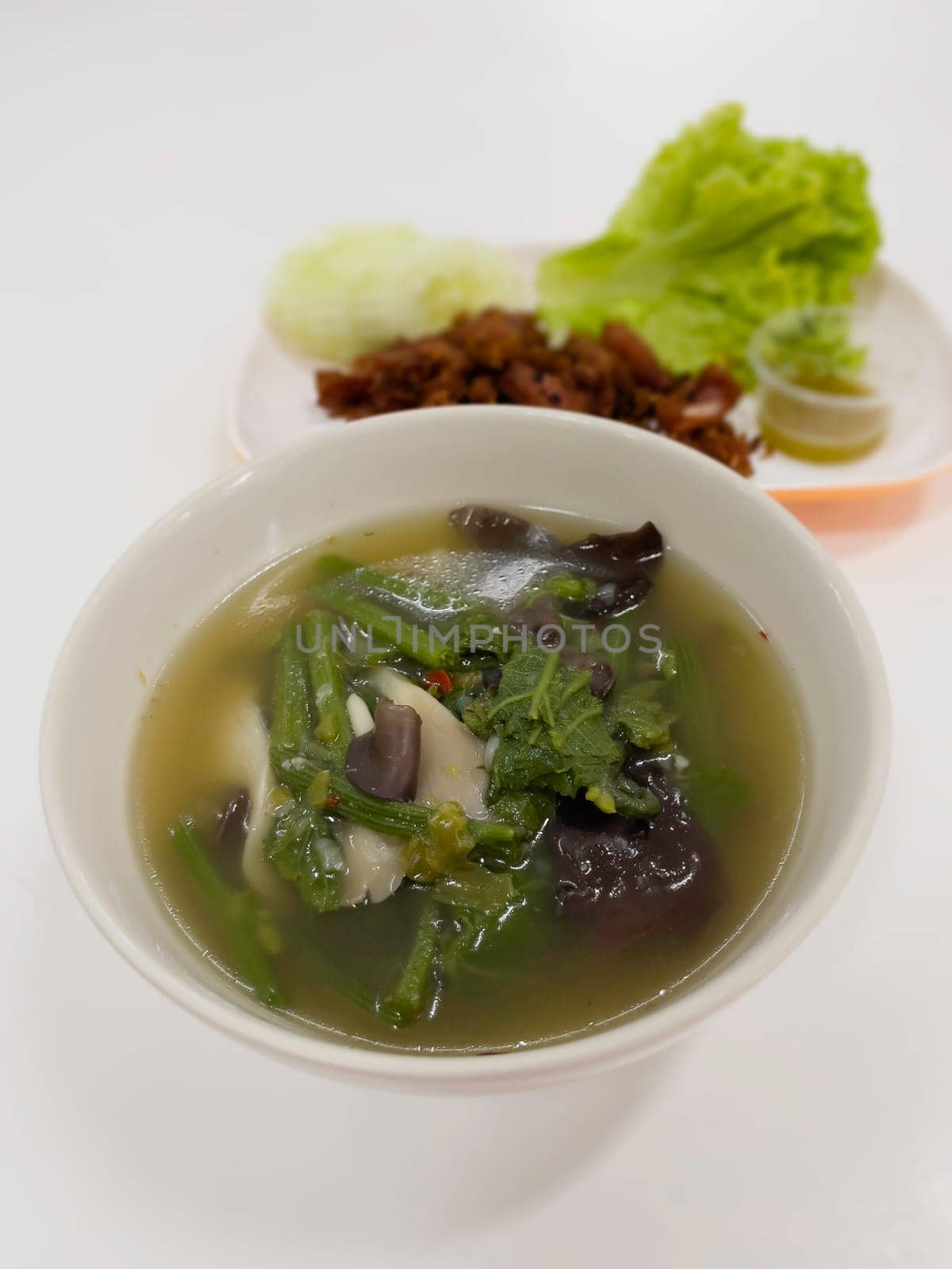 Home made kitchen bowl of soup with whole and sliced mushrooms, stock photo