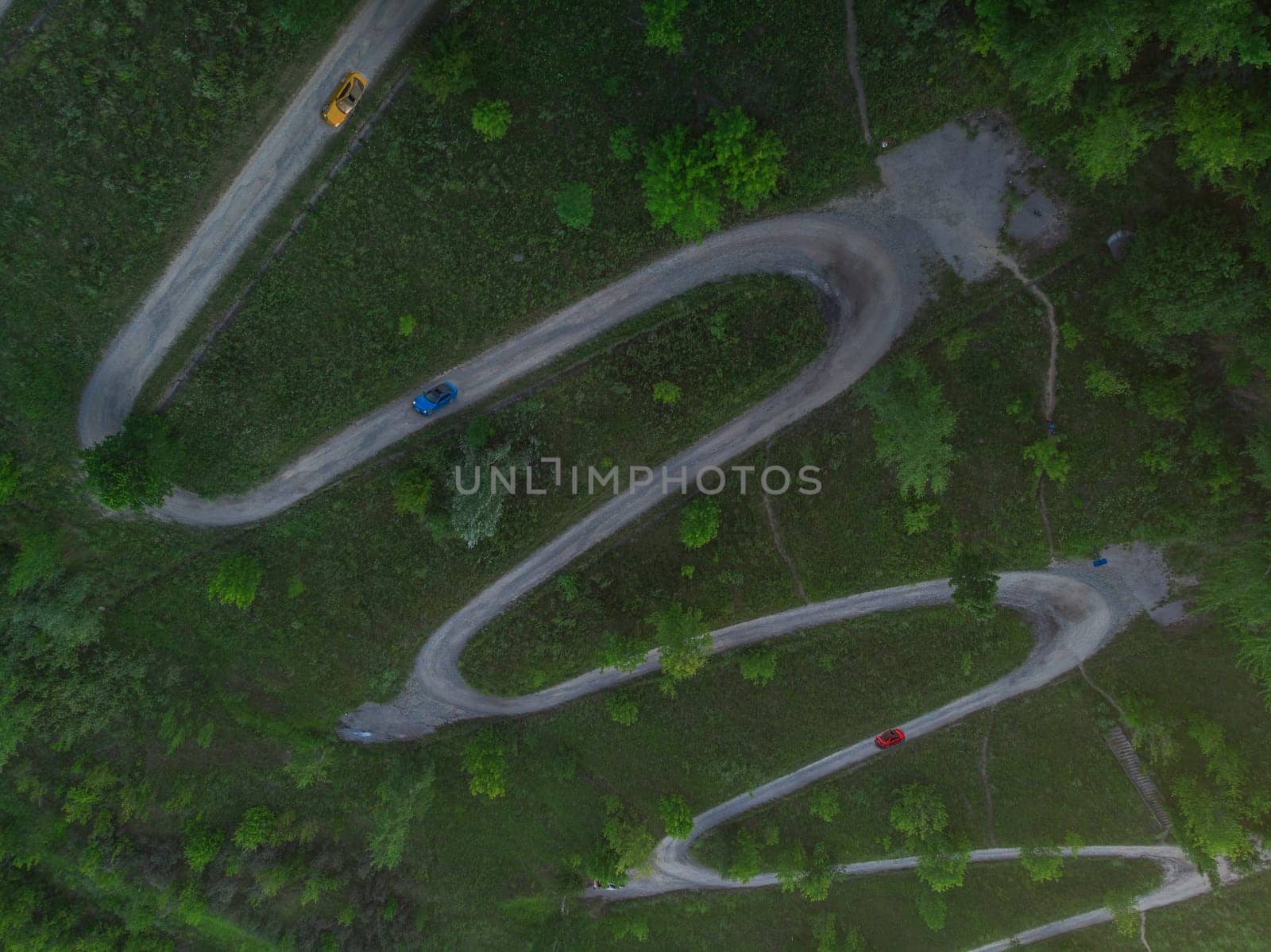 Aerial top vew of winding road in the city, with cars , drone shot