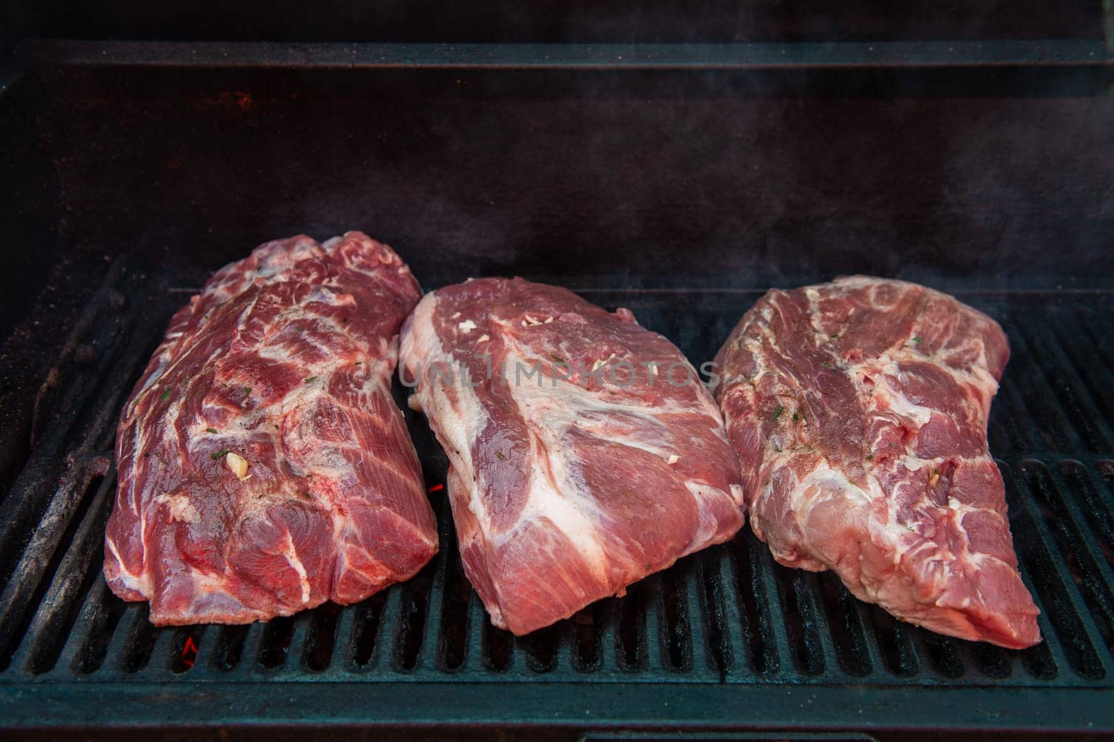 Pork meat steaks on the grill with flames