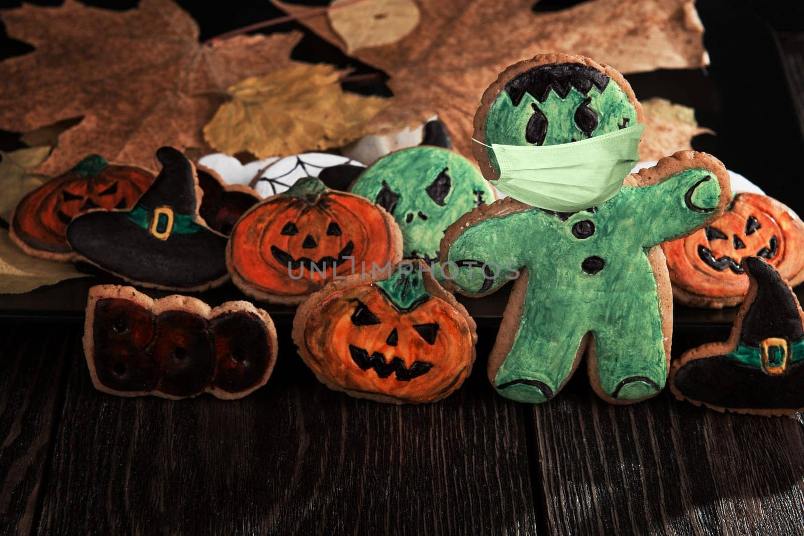 Ginger biscuits with face mask for Halloween holiday on wooden, concept of covid hallowen