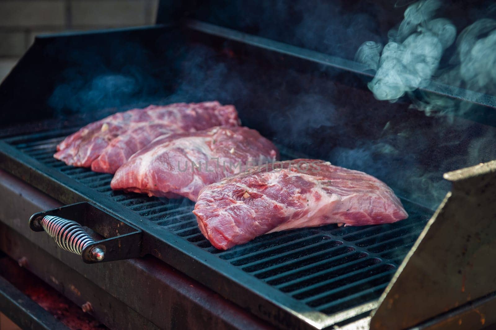 Pork meat steaks on the grill with flames