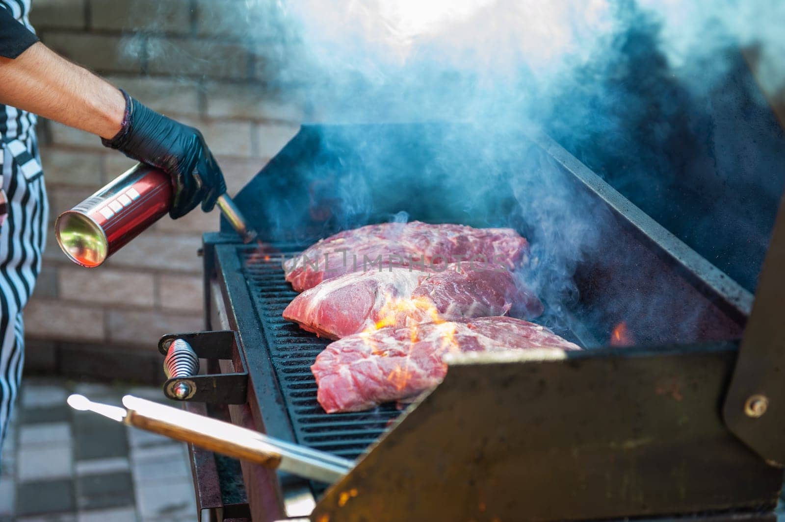 Pork meat steaks on the grill with flames