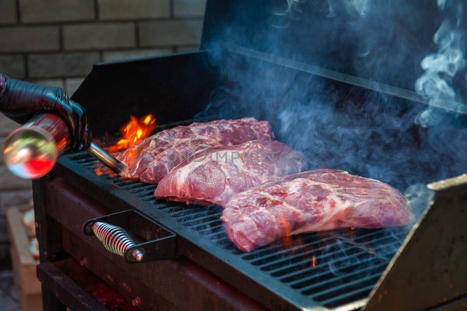 Pork meat steaks on the grill with flames