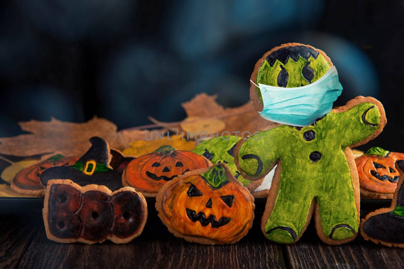 Ginger biscuits with face mask for Halloween holiday on wooden, concept of covid hallowen