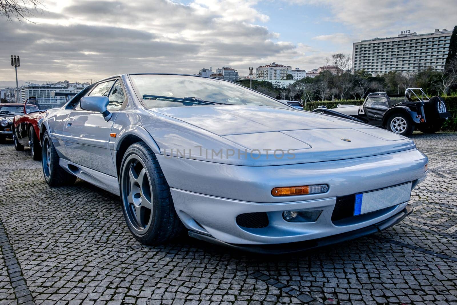 Lisbon, Portugal - Jan 20, 2024: Classic silver two-seater coupe of Lotus Esprit Sport 350 sports car parked on cobblestone pavement road.