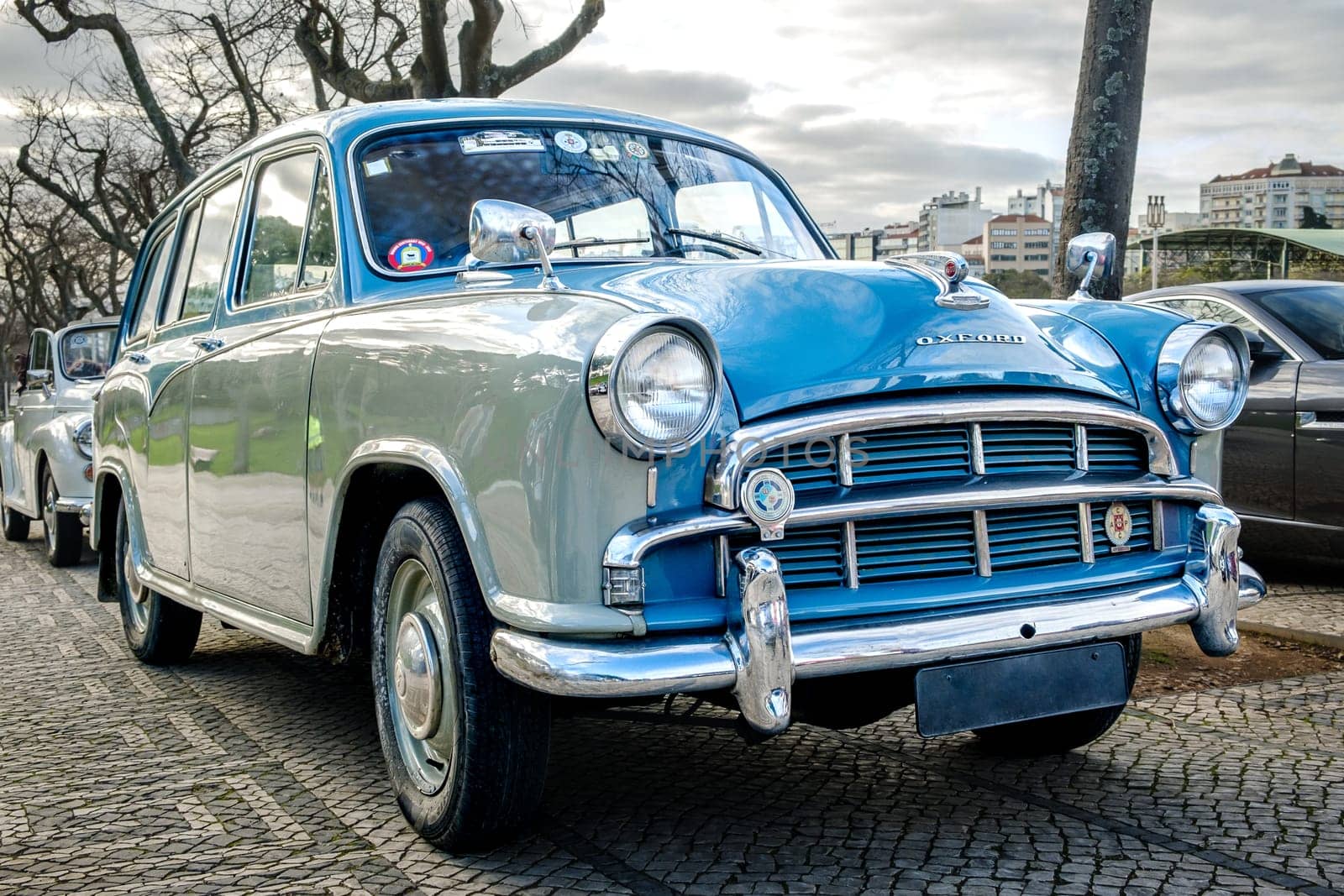 Lisbon, Portugal - Jan 20, 2024: A classic two-tone Morris Oxford Series III car parked on a cobblestone path on cloudy day, family car, two color coating, British Motor corporation
