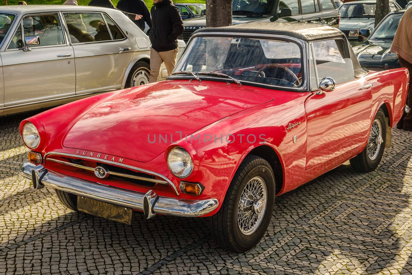 Lisbon, Portugal - Jan 20, 2024: Red Subeam Alpine Series IV vintage convertible sports car parked on cobblestone pavement road. Classice two-seater roadster or drophead coupe by Rootes Group, England, Great Britain