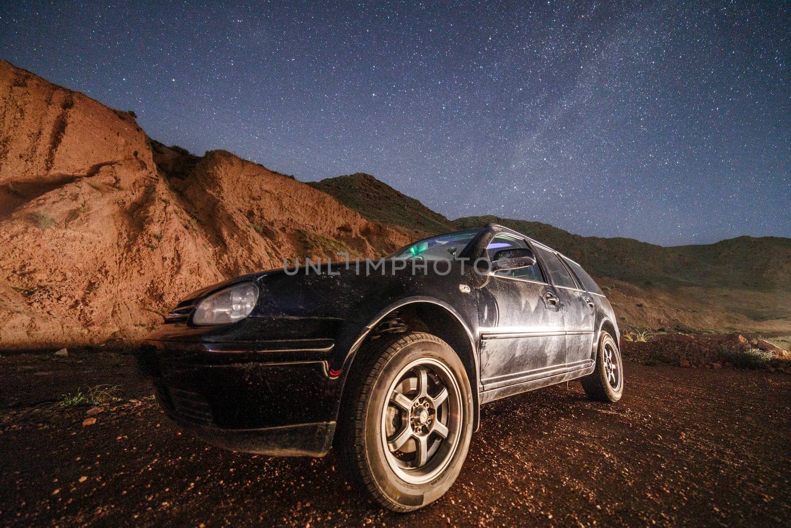 old black German station wagon car at starry summer night in the desert